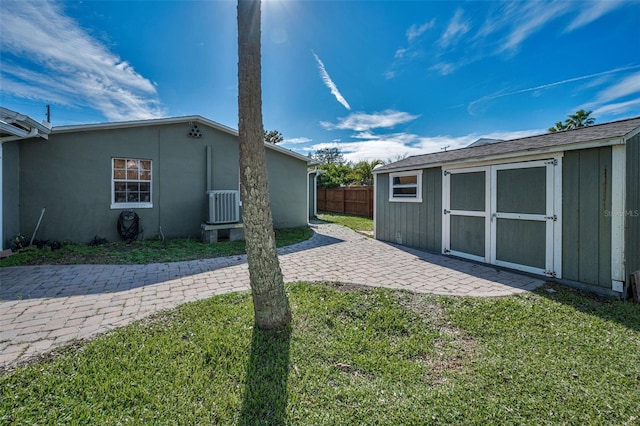 exterior space with a patio, a storage unit, fence, a yard, and an outdoor structure