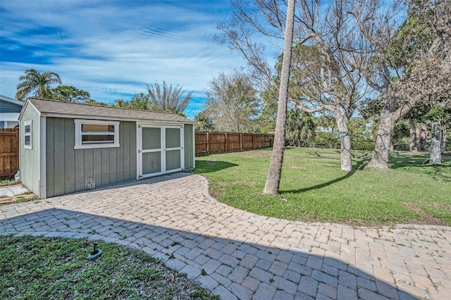 view of yard featuring an outbuilding, a fenced backyard, a patio, and a storage unit