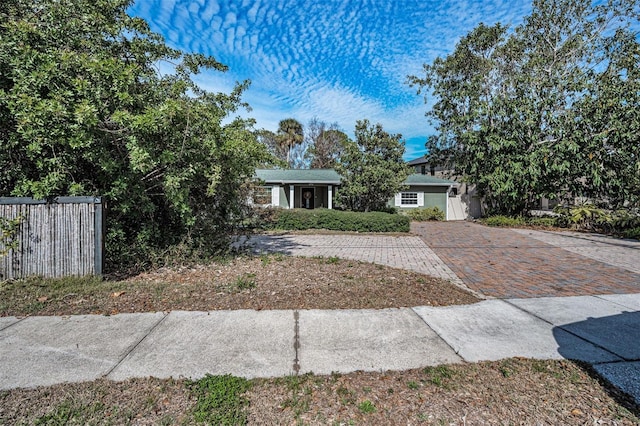 view of front of home featuring fence, decorative driveway, and stucco siding