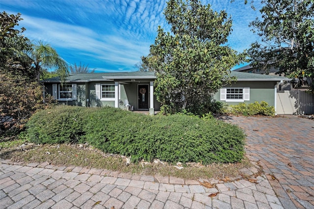 ranch-style house featuring fence and stucco siding