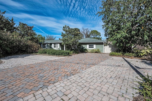 ranch-style home featuring a gate, fence, and stucco siding