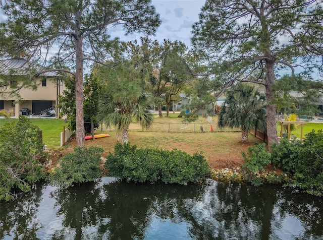 exterior space with a yard, a water view, and fence