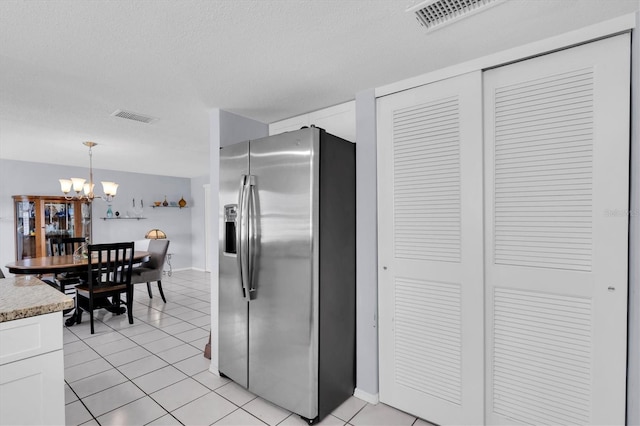 kitchen with visible vents, white cabinets, light tile patterned flooring, a chandelier, and stainless steel fridge with ice dispenser