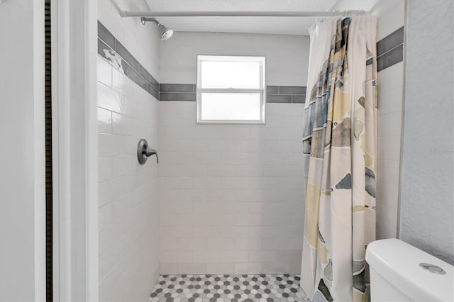 full bath featuring a shower stall and toilet