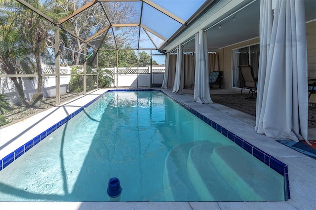 view of swimming pool featuring glass enclosure, a patio area, a fenced backyard, and a fenced in pool