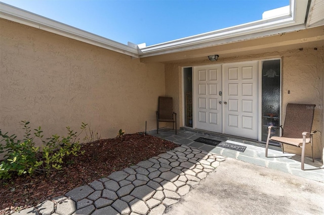 view of exterior entry with stucco siding