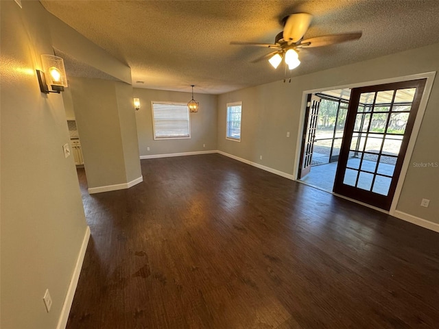 unfurnished room featuring a textured ceiling, ceiling fan, and dark hardwood / wood-style floors