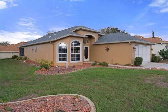ranch-style home with driveway, an attached garage, a front yard, roof with shingles, and stucco siding