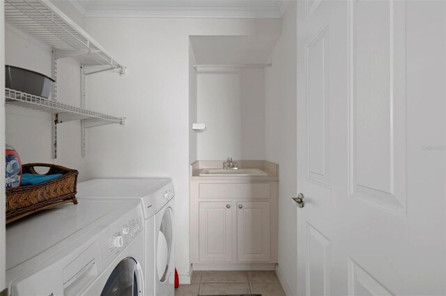 washroom with light tile patterned floors, a sink, ornamental molding, and separate washer and dryer
