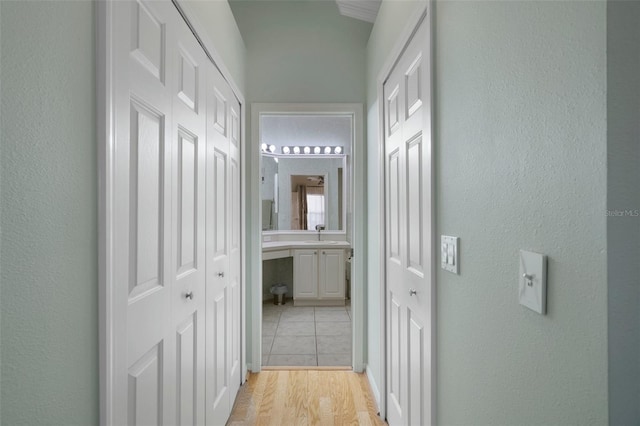 hall featuring a sink and light wood finished floors