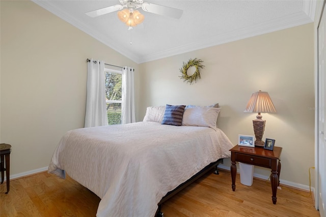 bedroom with light wood finished floors, baseboards, lofted ceiling, and ornamental molding