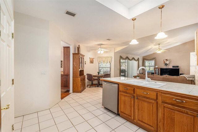 kitchen with a sink, open floor plan, hanging light fixtures, stainless steel dishwasher, and tile counters