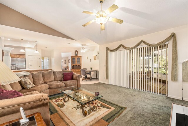 living area featuring vaulted ceiling, carpet floors, ceiling fan, and baseboards