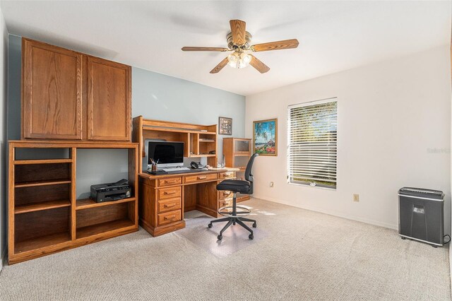 office space featuring light carpet and ceiling fan