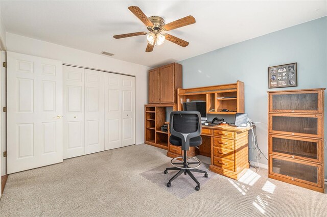 office with a ceiling fan, visible vents, and light carpet