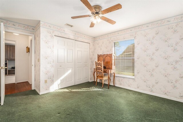 unfurnished bedroom with dark colored carpet, visible vents, and wallpapered walls