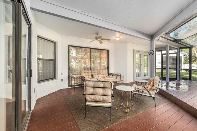 sunroom / solarium featuring ceiling fan, beamed ceiling, and a wealth of natural light