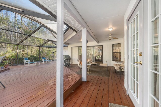 deck with glass enclosure, french doors, outdoor lounge area, and a ceiling fan