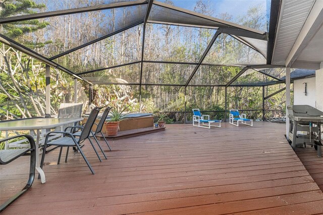 deck featuring glass enclosure, a grill, and a hot tub