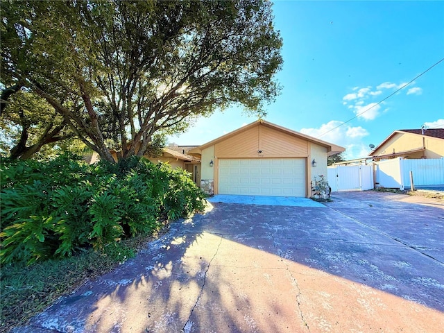 view of front of home featuring a garage, driveway, fence, and a gate