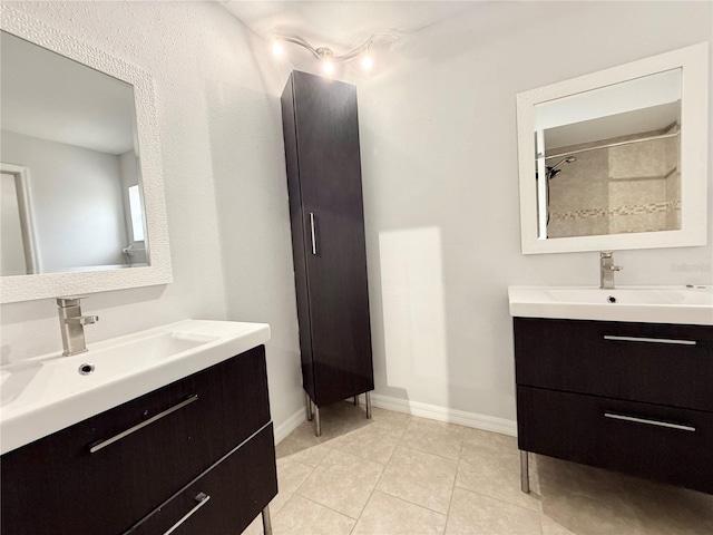 bathroom featuring baseboards, two vanities, a sink, and tile patterned floors