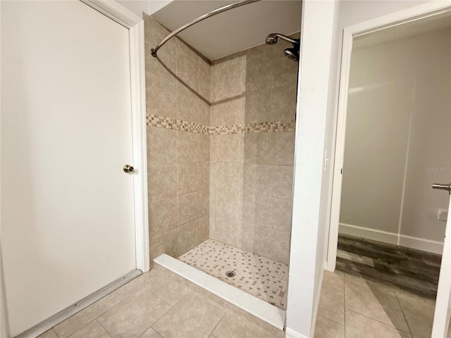 full bathroom with a stall shower and tile patterned flooring