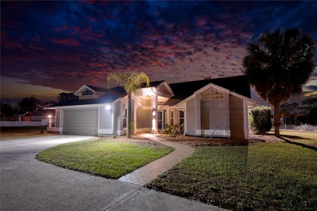 ranch-style house with a yard, driveway, and a garage