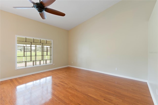 spare room featuring light wood finished floors, a ceiling fan, and baseboards