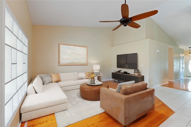 living room featuring a healthy amount of sunlight, baseboards, and high vaulted ceiling