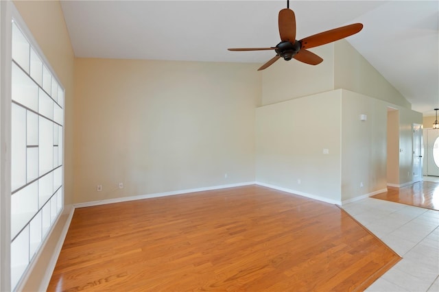 spare room featuring high vaulted ceiling, a healthy amount of sunlight, light wood-style flooring, and baseboards