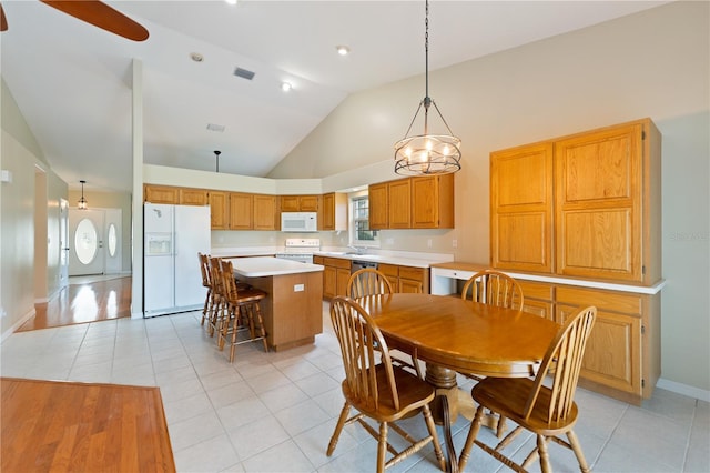 dining space with high vaulted ceiling, visible vents, baseboards, and light tile patterned floors