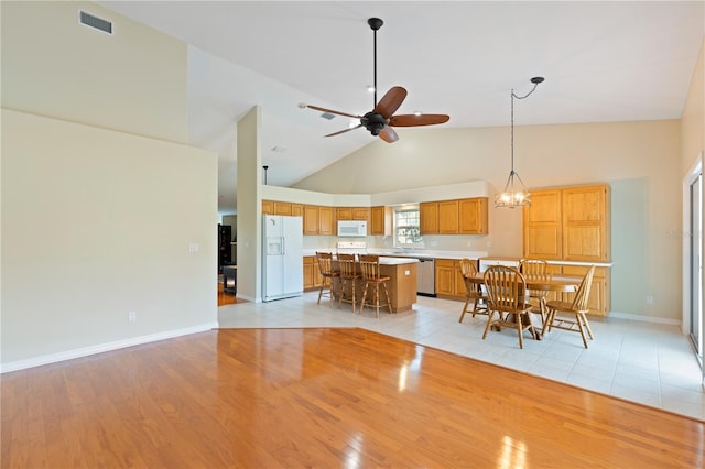 interior space with high vaulted ceiling, visible vents, ceiling fan, and light wood finished floors