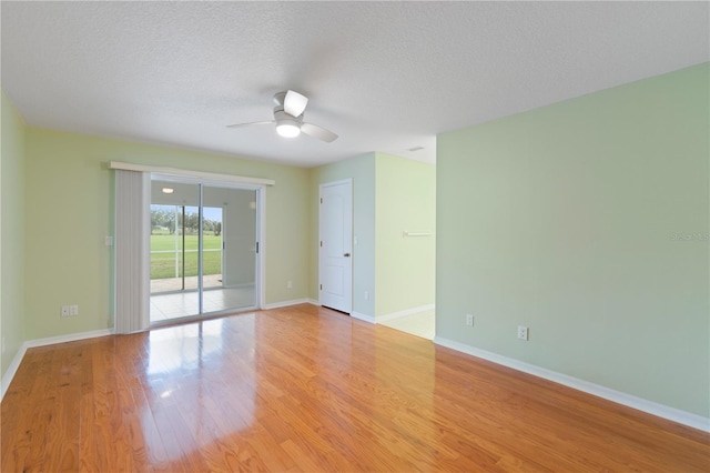 empty room featuring a ceiling fan, baseboards, a textured ceiling, and light wood finished floors