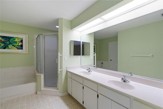 bathroom with a stall shower, a sink, and a skylight