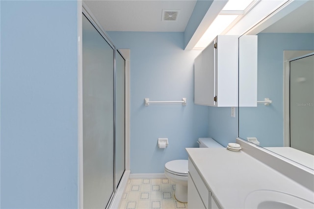 bathroom featuring visible vents, toilet, a shower stall, vanity, and baseboards