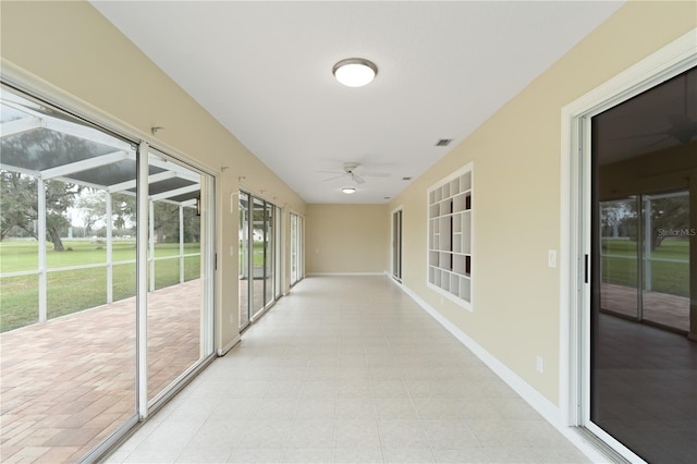 unfurnished sunroom featuring ceiling fan and visible vents