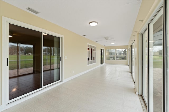 unfurnished sunroom featuring ceiling fan and visible vents