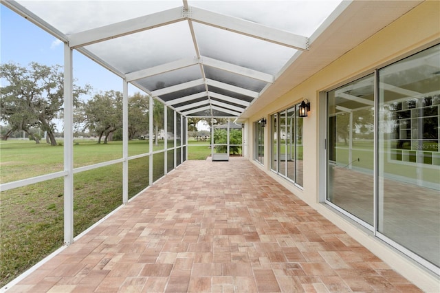 unfurnished sunroom featuring lofted ceiling with beams