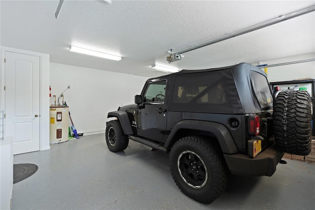 garage featuring electric water heater and baseboards