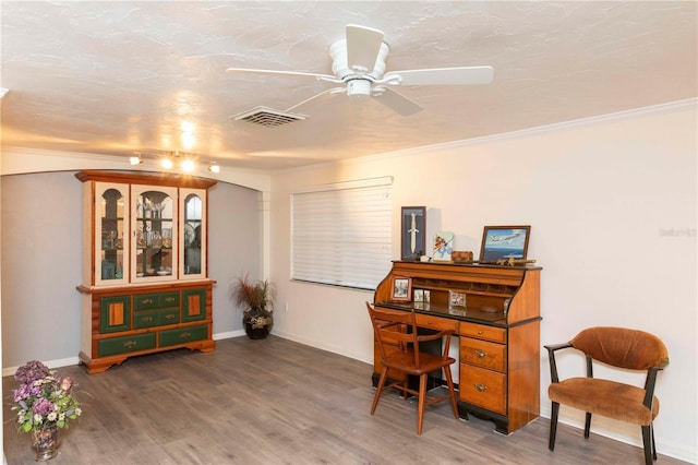 office area featuring baseboards, visible vents, a ceiling fan, ornamental molding, and wood finished floors