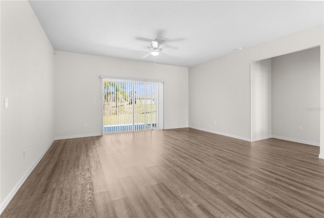 empty room with dark wood-type flooring, ceiling fan, and baseboards