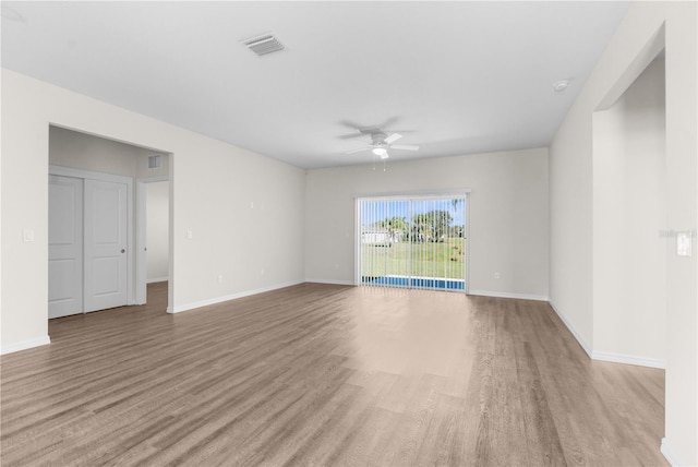 empty room featuring light wood-style flooring, visible vents, ceiling fan, and baseboards