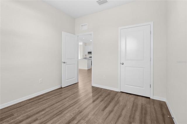 unfurnished bedroom featuring baseboards, visible vents, and light wood finished floors