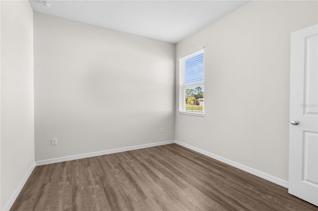 empty room featuring wood finished floors and baseboards