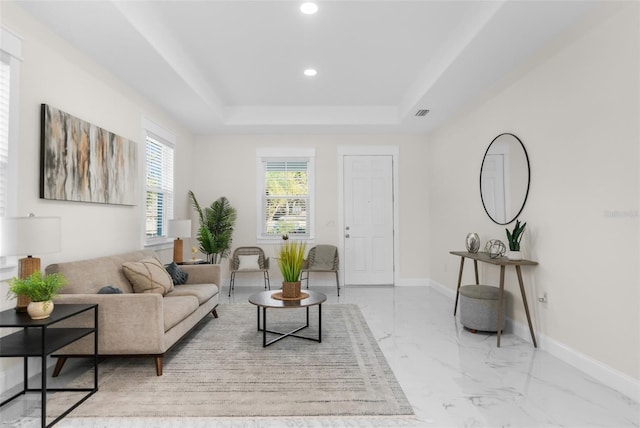 living area featuring marble finish floor, a tray ceiling, recessed lighting, and baseboards