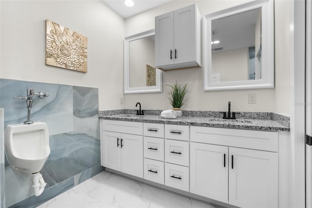 bathroom with marble finish floor, a sink, and double vanity