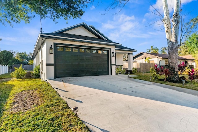 ranch-style house featuring stucco siding, concrete driveway, fence, a garage, and a front lawn