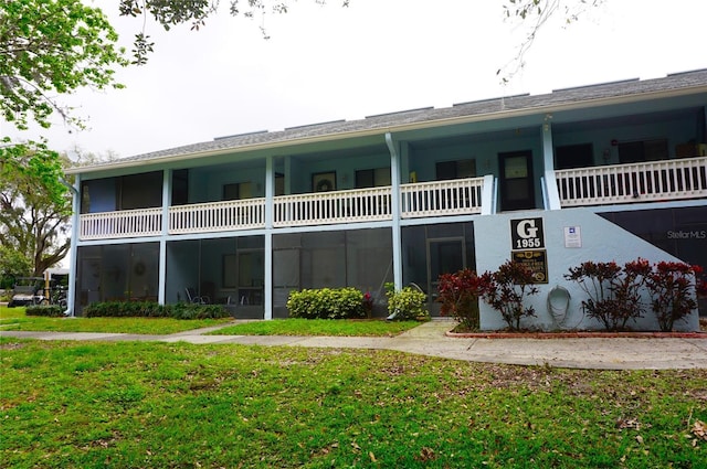 back of house with a yard and a balcony