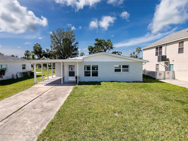 view of front facade featuring a carport, concrete driveway, central AC, and a front yard