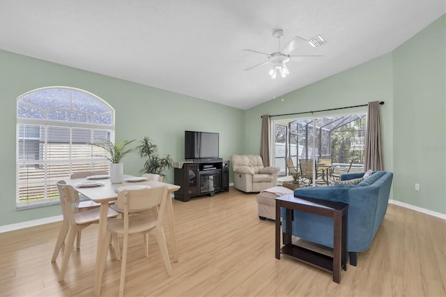 living room with light wood-style floors, ceiling fan, baseboards, and vaulted ceiling